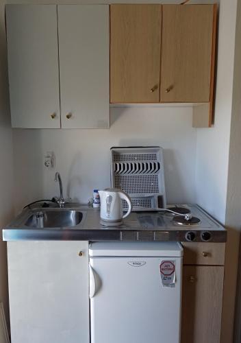 a small kitchen with a sink and a microwave at PANORAMA in Pitsidia