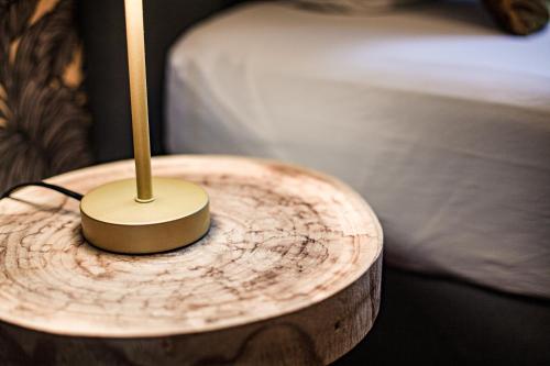 a wooden table with a lamp on top of a wooden stumpitures at Luxury Suites Historic Center by Rikas Hotels in Antwerp