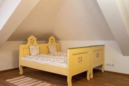 a yellow bed and a dresser in a room at Casa Kraus in Criţ