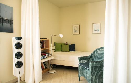 een kleine slaapkamer met een bed en een stoel bij Ferienwohnung im Wikingturm mit Blick auf die Schlei - Willkommen in Schleswig! in Schleswig
