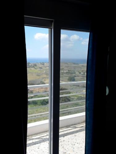 a view of the ocean from a window at PANORAMA in Pitsidia
