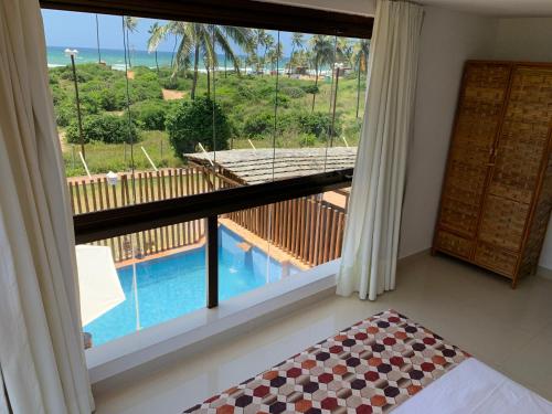 
a bedroom with a balcony overlooking the ocean at Villaggio Orizzonte in Salvador
