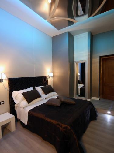 a bedroom with a large bed with blue lighting at Piccolo di Piazza di Spagna Suites in Rome