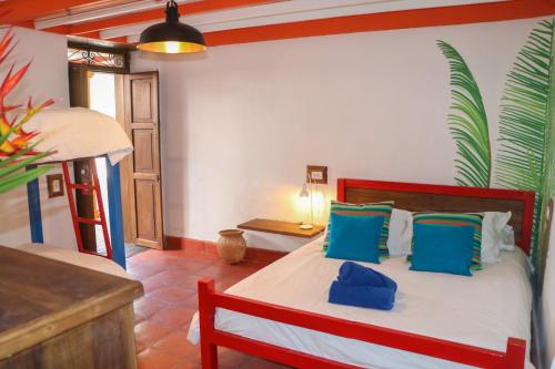 a bedroom with a bed with blue pillows at Finca La Manchuria in Salgar