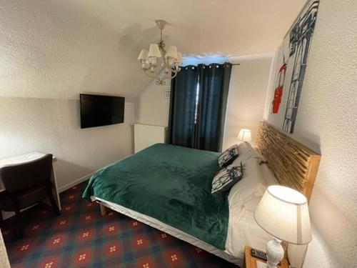 a bedroom with a bed and a desk and a television at Hotel Le Blanche Neige in Valberg
