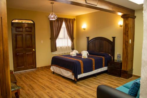 1 dormitorio con 1 cama grande y 1 sofá en Hotel Casa Texel, en Panajachel