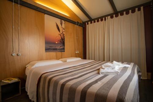 Una habitación de hotel con una cama con toallas. en Windresort en Granitola