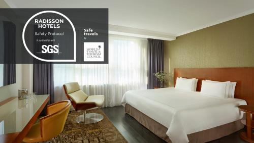 a hotel room with a large bed and a desk at Park Plaza Nottingham in Nottingham