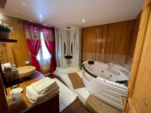 a large bathroom with a tub and a sink at Hotel Le Blanche Neige in Valberg