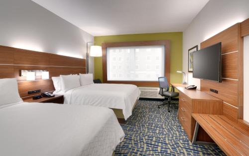 a hotel room with two beds and a flat screen tv at Holiday Inn Express & Suites - Gainesville I-75 by IHG in Gainesville