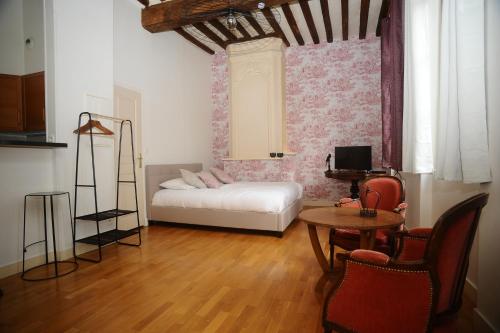 un salon avec un lit, une table et des chaises dans l'établissement La Chambre d'Emma, à Dieppe