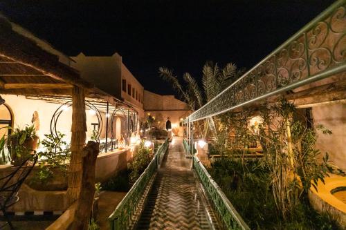 a walkway leading to a building at night at Kasbah Mohayut in Merzouga