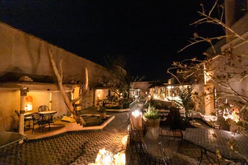 a patio with tables and chairs at night at Kasbah Mohayut in Merzouga