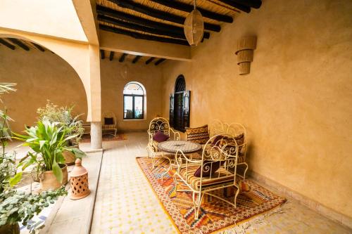 a patio with a table and chairs on a rug at Kasbah Mohayut in Merzouga