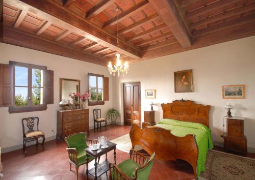 a bedroom with a bed and a table and chairs at Villa Di Collina in Vicchio