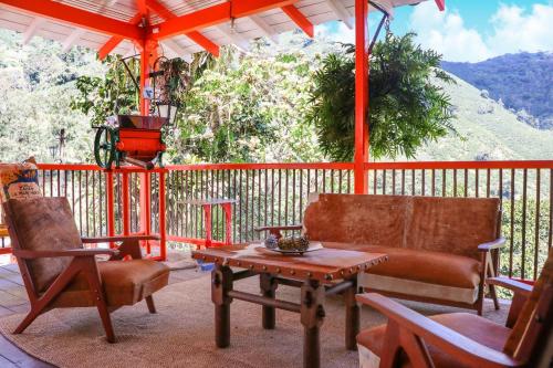 a porch with chairs and a table and a couch at Finca La Manchuria in Salgar