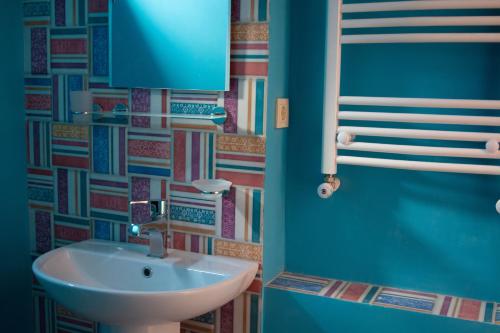 a bathroom with a sink and a blue wall at Sunflower Hotel in Tbilisi City