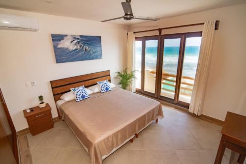 a bedroom with a bed with a view of the ocean at Villas Najo' Isla Mujeres. in Isla Mujeres