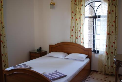 a bedroom with a bed and a window with curtains at Albuquerque BetterHomes, Goa in Candolim