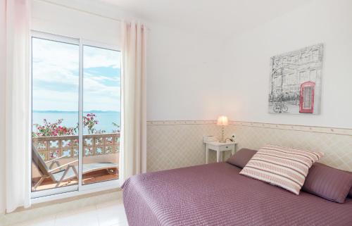 a bedroom with a bed and a large window at Villa Buraux III in Roses