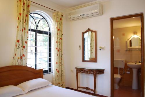 坎多林的住宿－Albuquerque BetterHomes, Goa，一间卧室配有床、水槽和镜子
