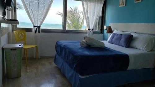 1 dormitorio con cama y ventana con vistas al océano en Departamento frente al Mar - Kiara en Cancún