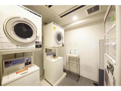 a laundry room with a washing machine and a washer at R&B HOTEL HACHIOJI - Vacation STAY 13872v in Hachioji