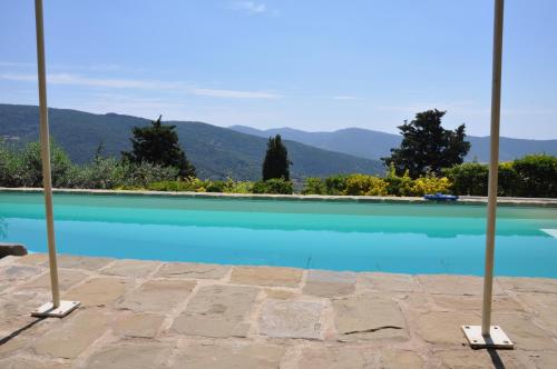 una piscina blu con montagne sullo sfondo di Villa Rosa a Cortona