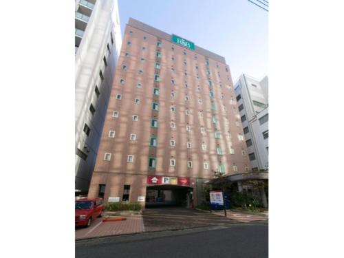 a large brown building with a parking lot in front of it at R&B HOTEL NAGOYA SAKAE HIGASHI - Vacation STAY 14030v in Nagoya