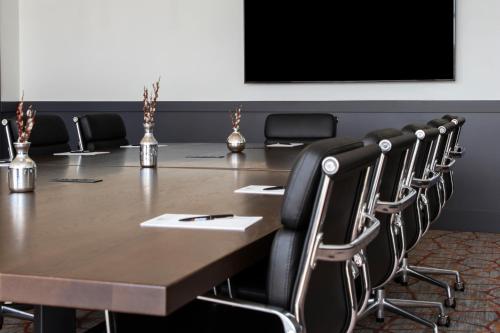 a conference room with a large wooden table and chairs at Origin Westminster a Wyndham Hotel in Westminster