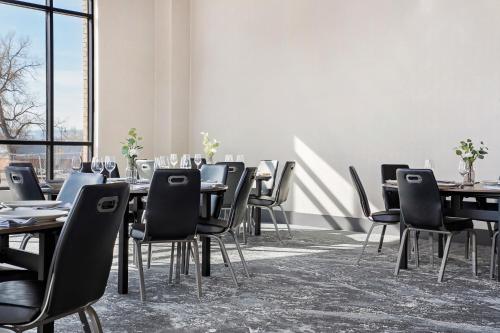 a dining room with tables and chairs and windows at Origin Westminster a Wyndham Hotel in Westminster