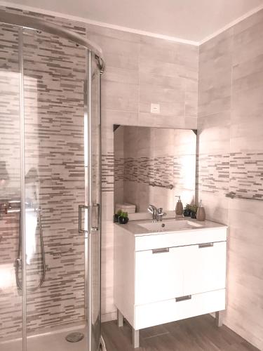 a white bathroom with a sink and a shower at Casa Sambinho Gerês in Rio Caldo