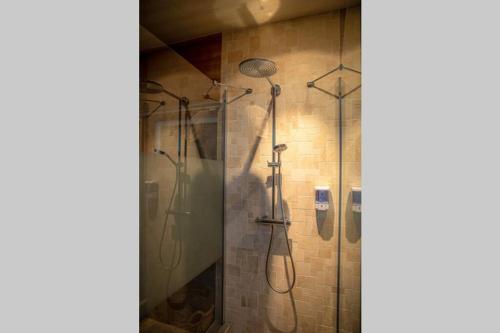 a shower stall with four shower heads in a bathroom at Le Spa du Cabanon: Cabanon de luxe avec Spa entièrement privatif in Aye