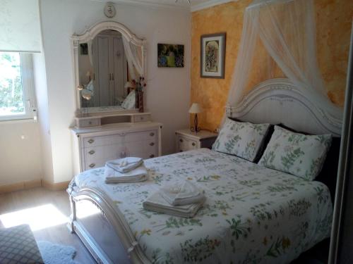 a bedroom with a bed with a dresser and a mirror at Casa o Furco in Foz