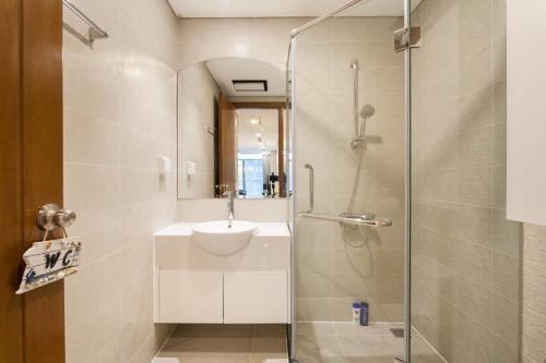 y baño con lavabo y ducha acristalada. en Vinhomes Central Park -Luxury Apartment en Ho Chi Minh