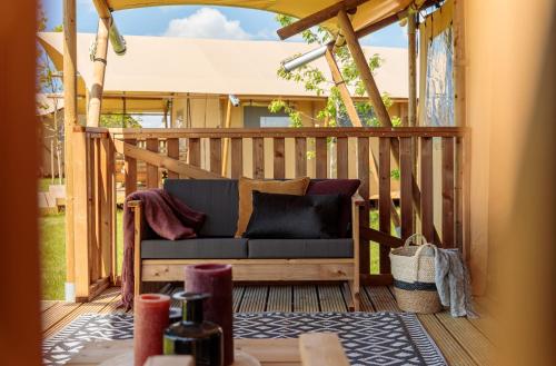 a porch with a couch on a wooden deck at Frei wie der Wind-Glamping in Dierhagen