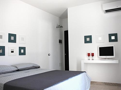 1 dormitorio con 1 cama y TV en la pared en Corte Baracca B&B Suite en Matino