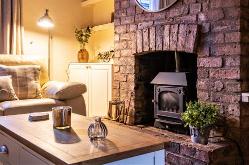 uma sala de estar com uma lareira de pedra e um fogão em The Cottage in Chester, Sleeps 6 with FREE Parking em Chester