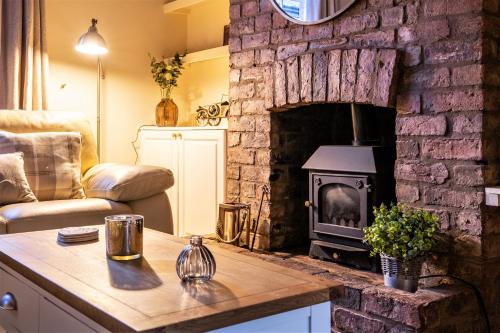 een woonkamer met een stenen open haard en een fornuis bij The Cottage in Chester, Sleeps 6 with FREE Parking in Chester