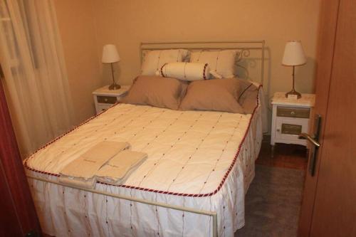 a bed in a room with two night stands and two lamps at Casa da Juraci in Sabrosa