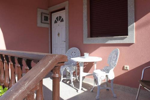 a table and chairs sitting on a porch with a table and chairs at Casa da Juraci in Sabrosa