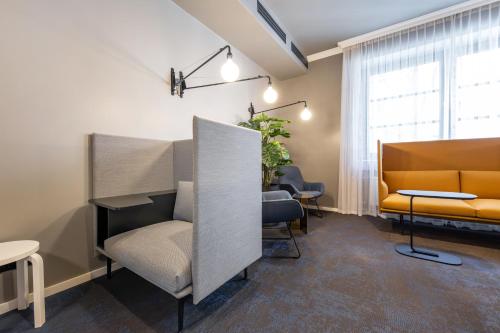 a waiting room with a couch and a chair at B-Hotel in Düsseldorf
