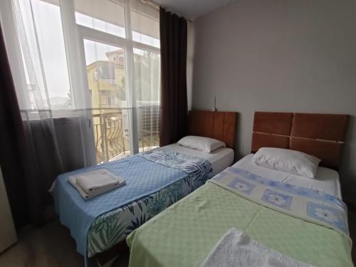 twee bedden in een kamer met een raam bij Vienna Apart Otel in Antalya