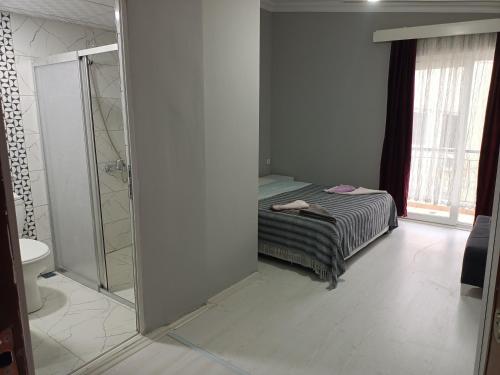 een badkamer met een bed, een douche en een spiegel bij Vienna Apart Otel in Antalya