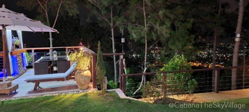 a woman sitting on a bench next to a fence at Villa The sky village in Jarabacoa