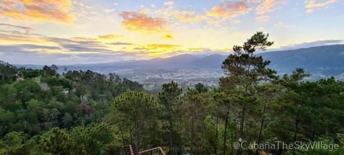 a view of a city from a hill with trees at Villa The sky village in Jarabacoa
