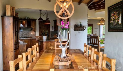 a dining room with a table with a vase of flowers at Villa The sky village in Jarabacoa