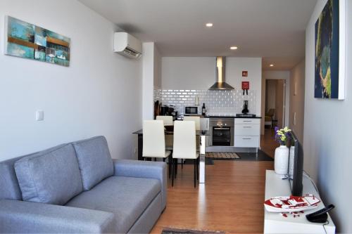 ポンタ・デルガダにあるOcean Blue Apartmentのソファとキッチンのあるリビングルーム