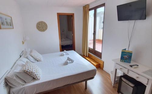 a bedroom with a bed and a desk with a television at Hotel Mireia in Lloret de Mar