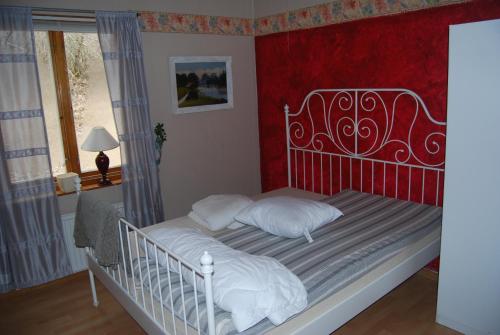 a bedroom with a white bed with a red wall at Ferienhaus Malaskog 4 Naturschutzgebiet in Ryssby